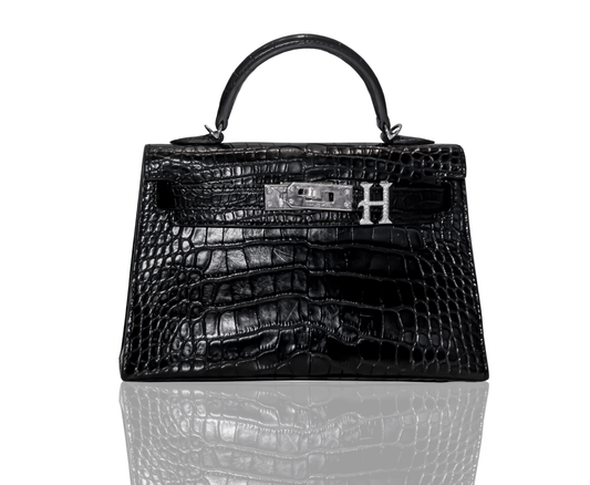 A black handbag with a crocodile pattern and a silver brooch with the letter 'H' on the front, collection-preview.