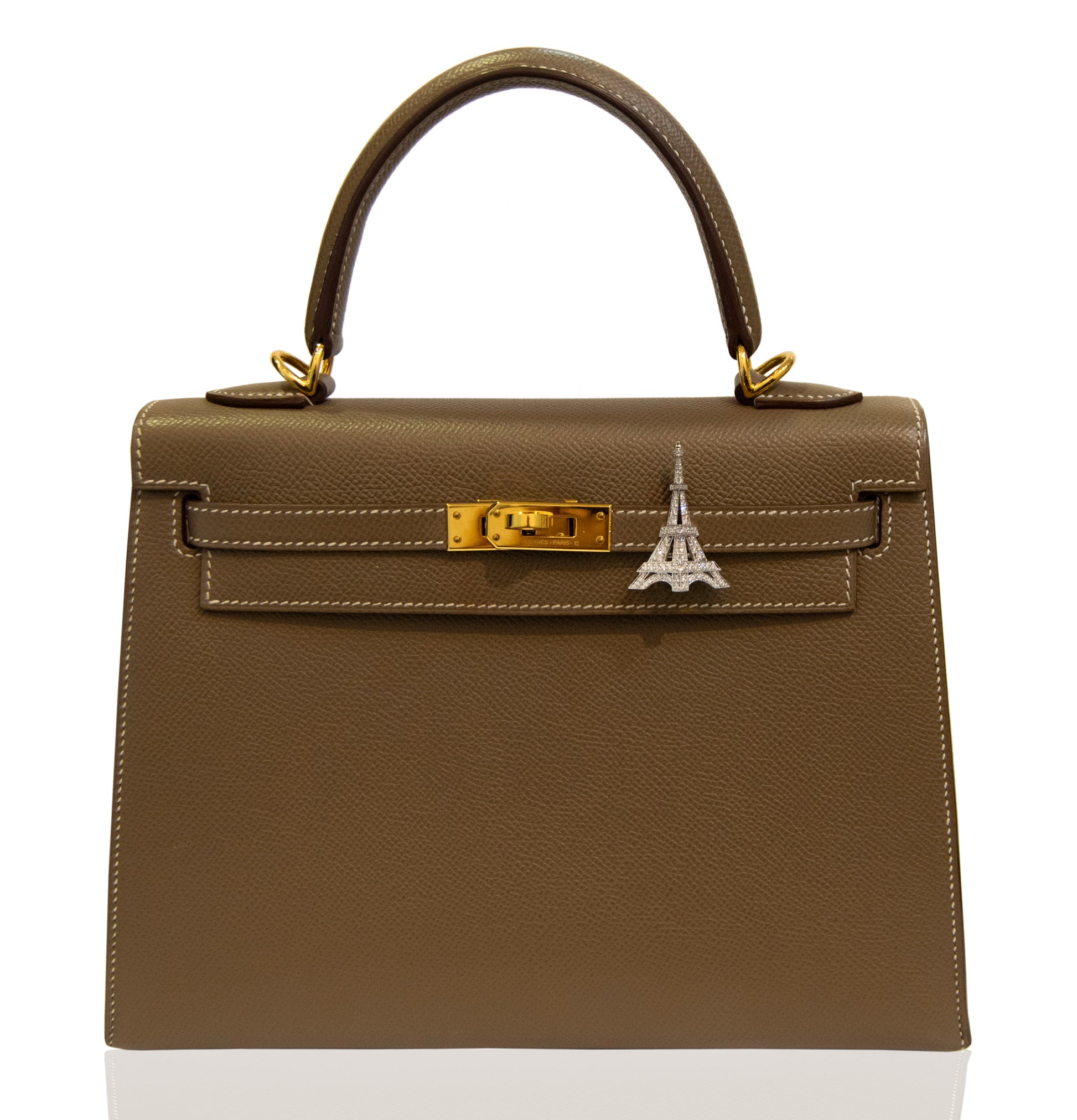 Brown handbag with a silver Eiffel Tower charm on a white background, collection-preview