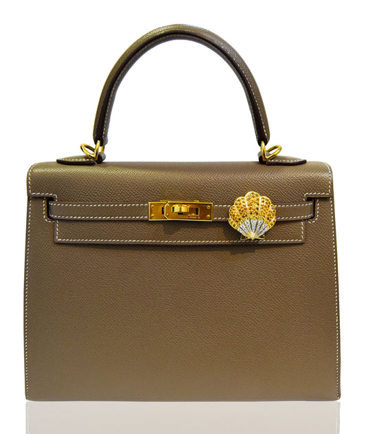 Brown handbag with gold clasp and emblem on a white background, collection-preview