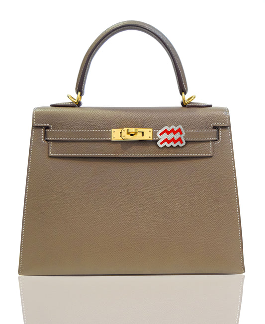 Brown handbag with gold hardware and a red and white tag on a white , collection-previewbackground