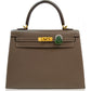 Brown handbag with gold hardware and a green clasp on a white background, collection-preview