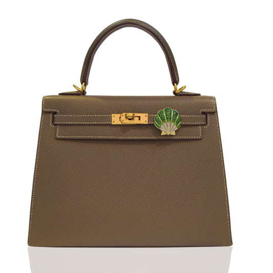 Brown handbag with a green and gold emblem on a white background, collection-preview