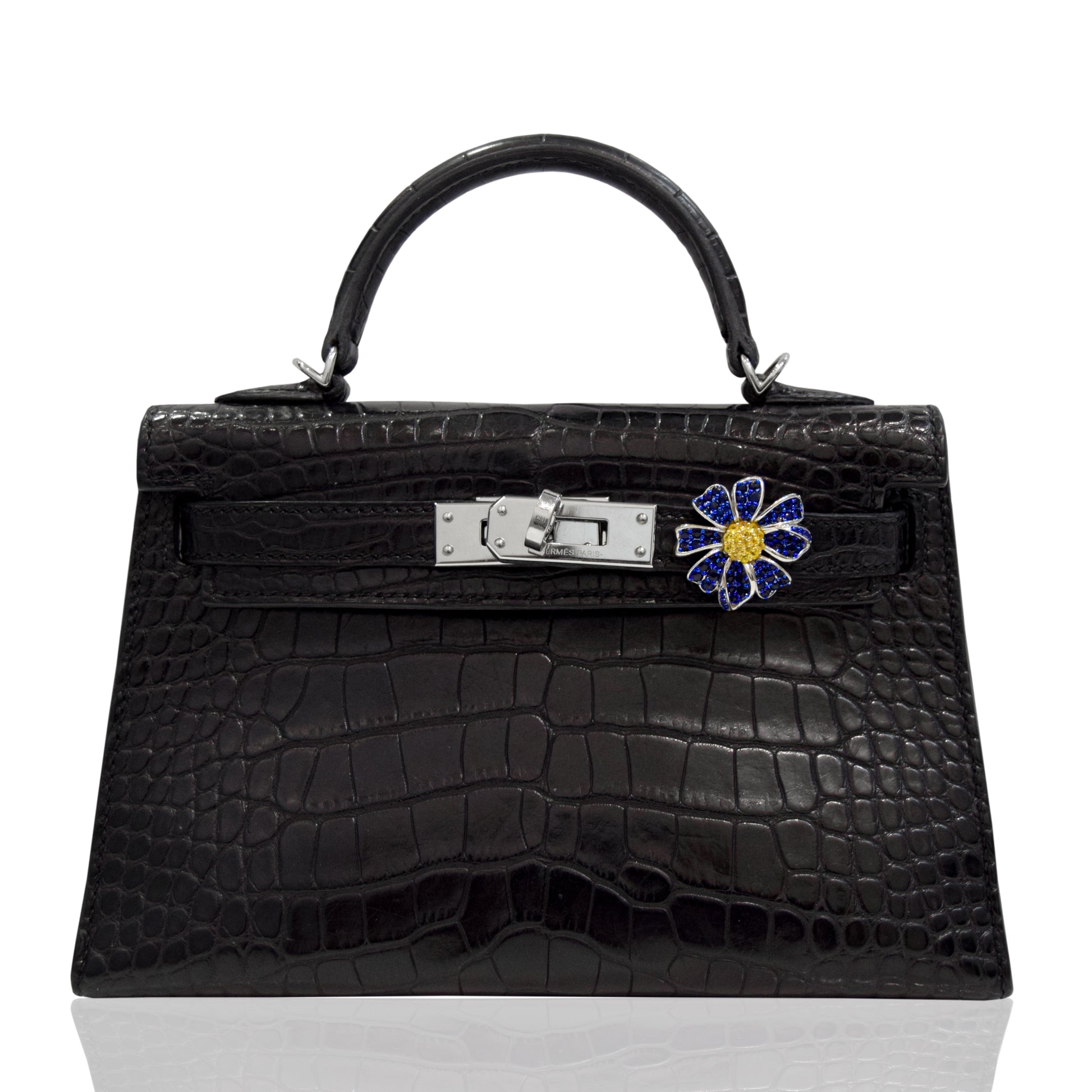 Black crocodile skin handbag with a decorative clasp on a white background, collection-preview