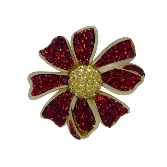 Floral brooch with red gemstones and gold center on a white background