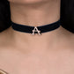 Black choker necklace with a gold letter 'A' pendant on a person's neck.