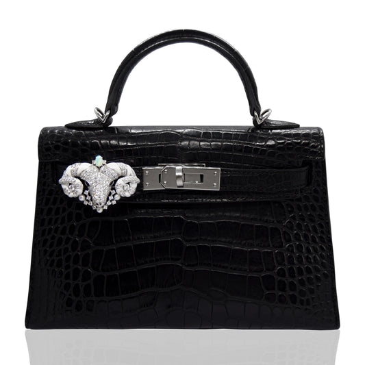 Black crocodile skin handbag with decorative clasp on a white background, collection-preview