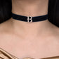 Navy velvet choker with a decorative 'B' clasp worn by a person.