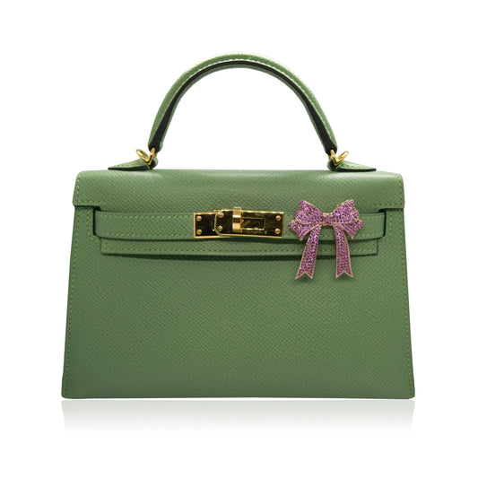 Green handbag with a pink bow on a white background, collection-preview
