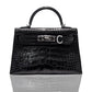 A black handbag with a crocodile pattern and a metallic clasp, resembling a high-end leather handbag, collection-preview.