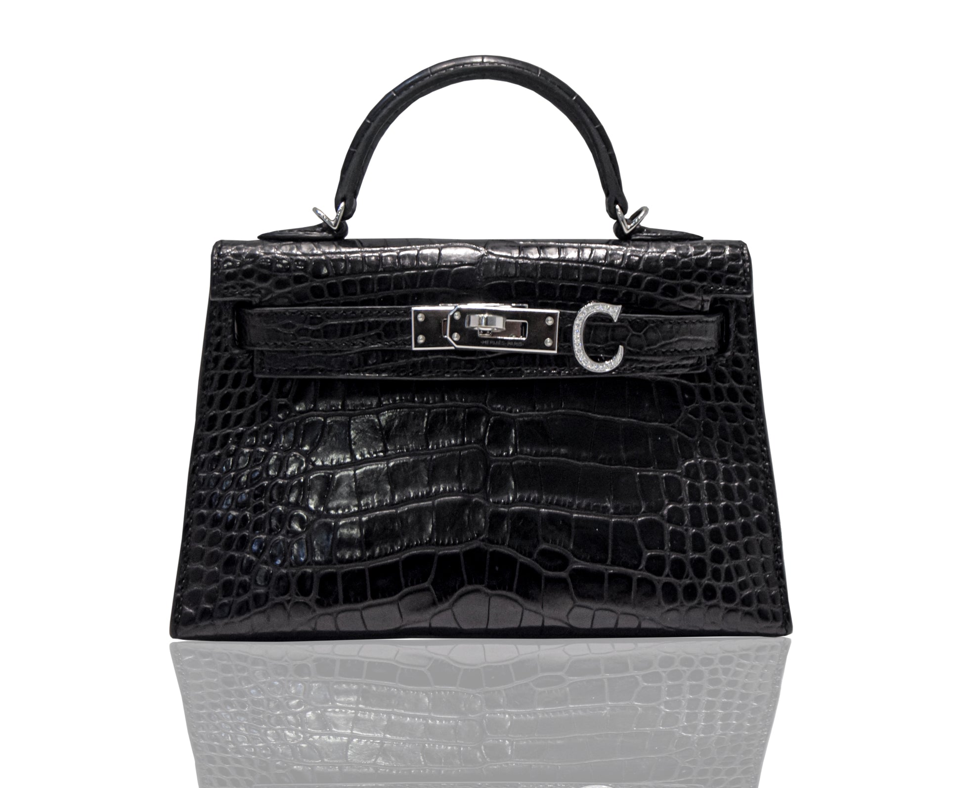 A black handbag with a crocodile pattern and a metallic clasp, resembling a high-end leather handbag, collection-preview.