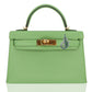 Green handbag with gold hardware on a white background, collection-preview