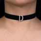 Black choker necklace with a diamond 'D' clasp on a person's neck.