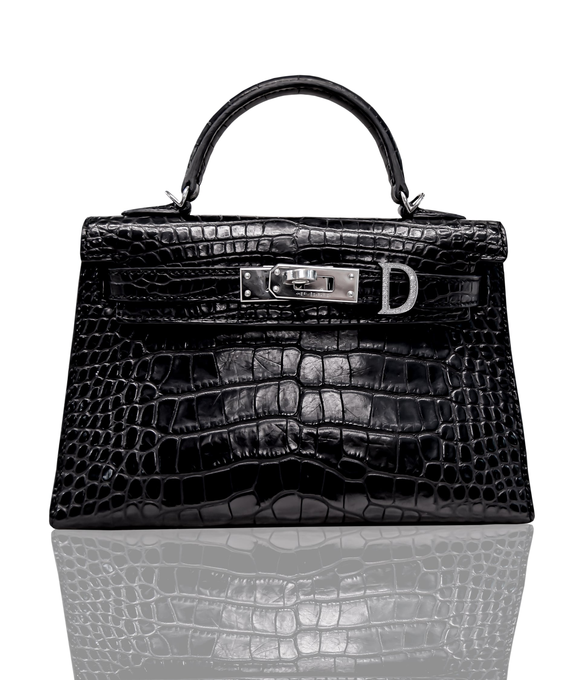 A black handbag with a crocodile pattern and a metallic clasp, resembling a 'D' shaped hardware, typically seen on luxury leather handbags, collection-preview.