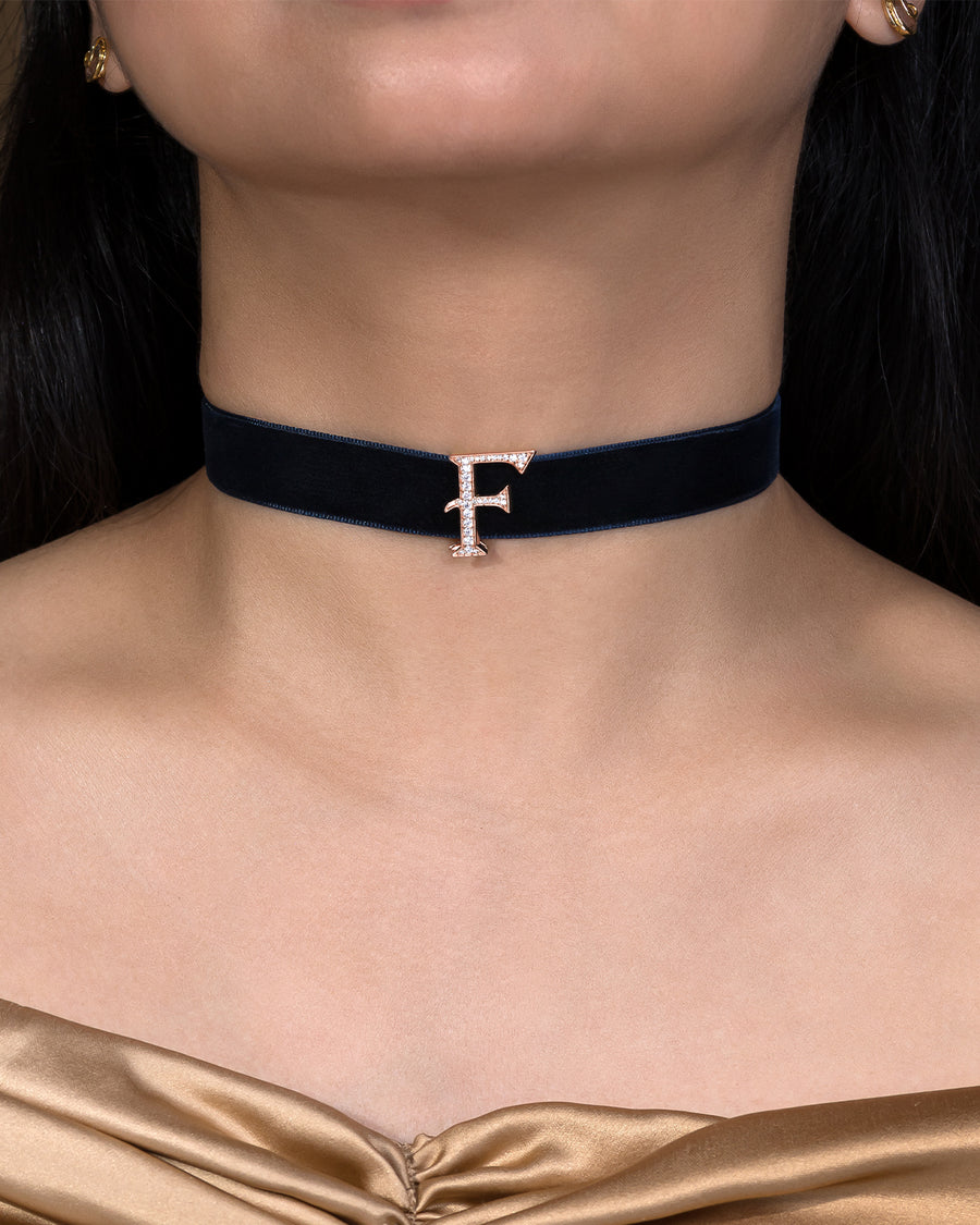 Black velvet choker with a decorative 'F' charm worn by a model.