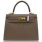 A brown handbag with a France flag Bijoux accessory attached to its clasp, collection-preview.