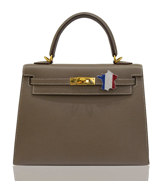 A brown handbag with a France flag Bijoux accessory attached to its clasp, collection-preview.