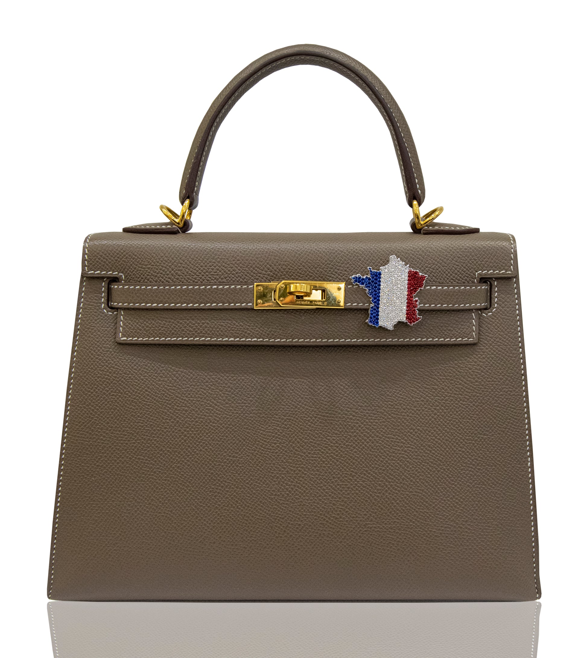 A brown handbag with a France flag Bijoux accessory attached to its clasp, collection-preview.