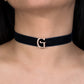 Black choker with a gold 'G' clasp worn by a person