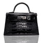 A black handbag with a crocodile pattern and a metallic clasp with the letter 'G' on it, resembling a luxury brand's design, collection-preview.