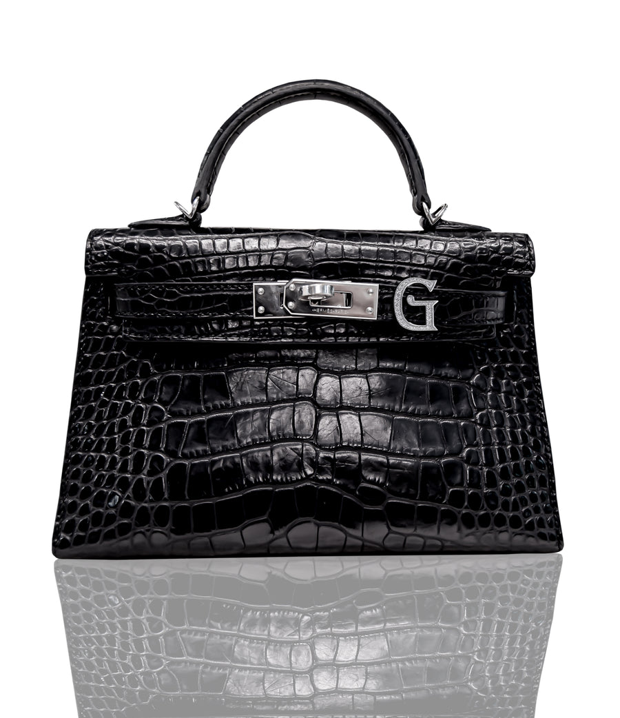 A black handbag with a crocodile pattern and a metallic clasp with the letter 'G' on it, resembling a luxury brand's design, collection-preview.