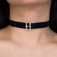 Navy blue choker with a gold 'H' pendant on a person's neck.