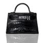 A black handbag with a crocodile pattern and a silver brooch with the letter 'H' on the front, collection-preview.