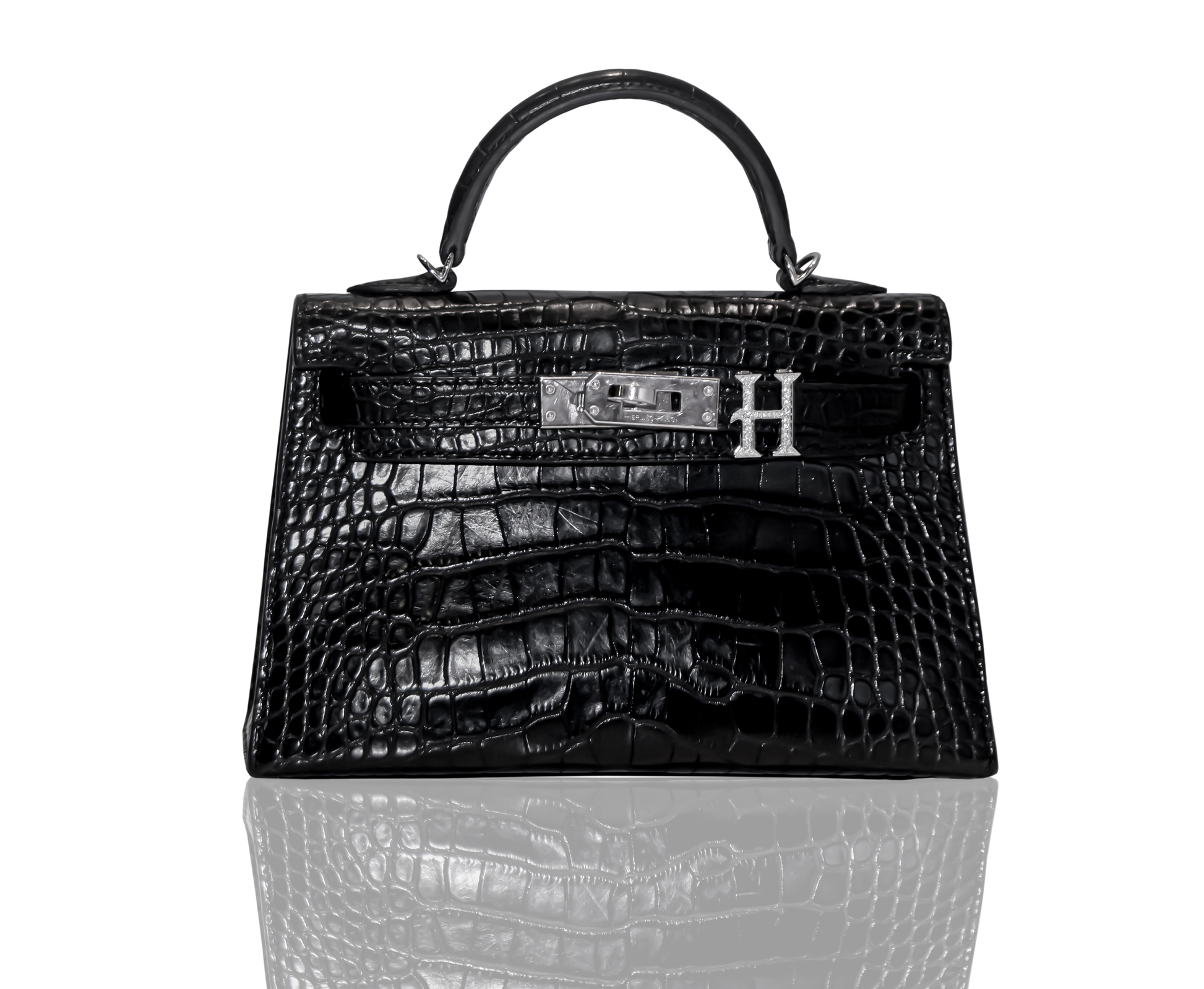 A black handbag with a crocodile pattern and a silver brooch with the letter 'H' on the front, collection-preview.