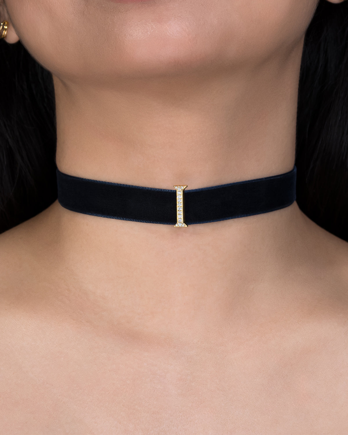 Black choker necklace with a small diamond pendant on a person's neck.