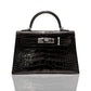 A luxurious handbag with a black exterior and metallic hardware, featuring a crocodile pattern, collection-preview.