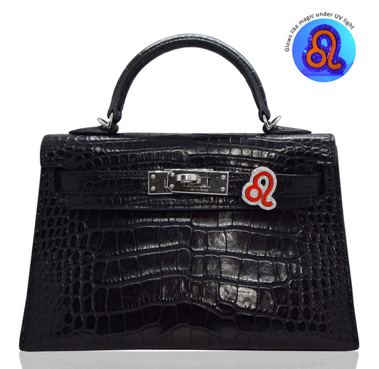 Black crocodile skin handbag with a visible brand logo on a white background, collection-preview