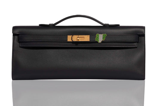 A black handbag with gold hardware, featuring a diamond and emerald embellishment on the front, collection-preview.