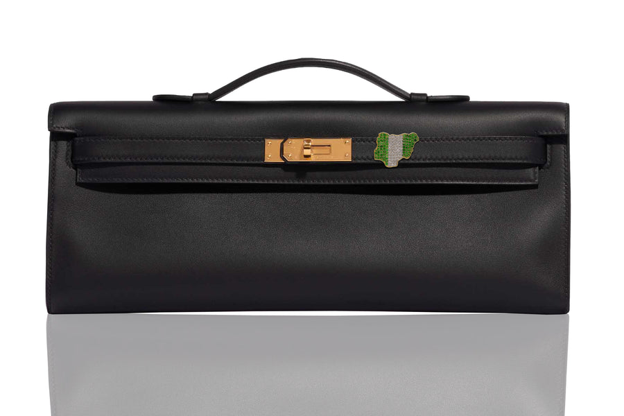 A black handbag with gold hardware, featuring a diamond and emerald embellishment on the front, collection-preview.