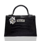 Black crocodile skin handbag with silver hardware on a white background, collection-preview