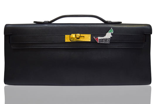 A black handbag with a UAE flag detail on the front, featuring a gold clasp and adorned with a diamond brooch, collection-preview.