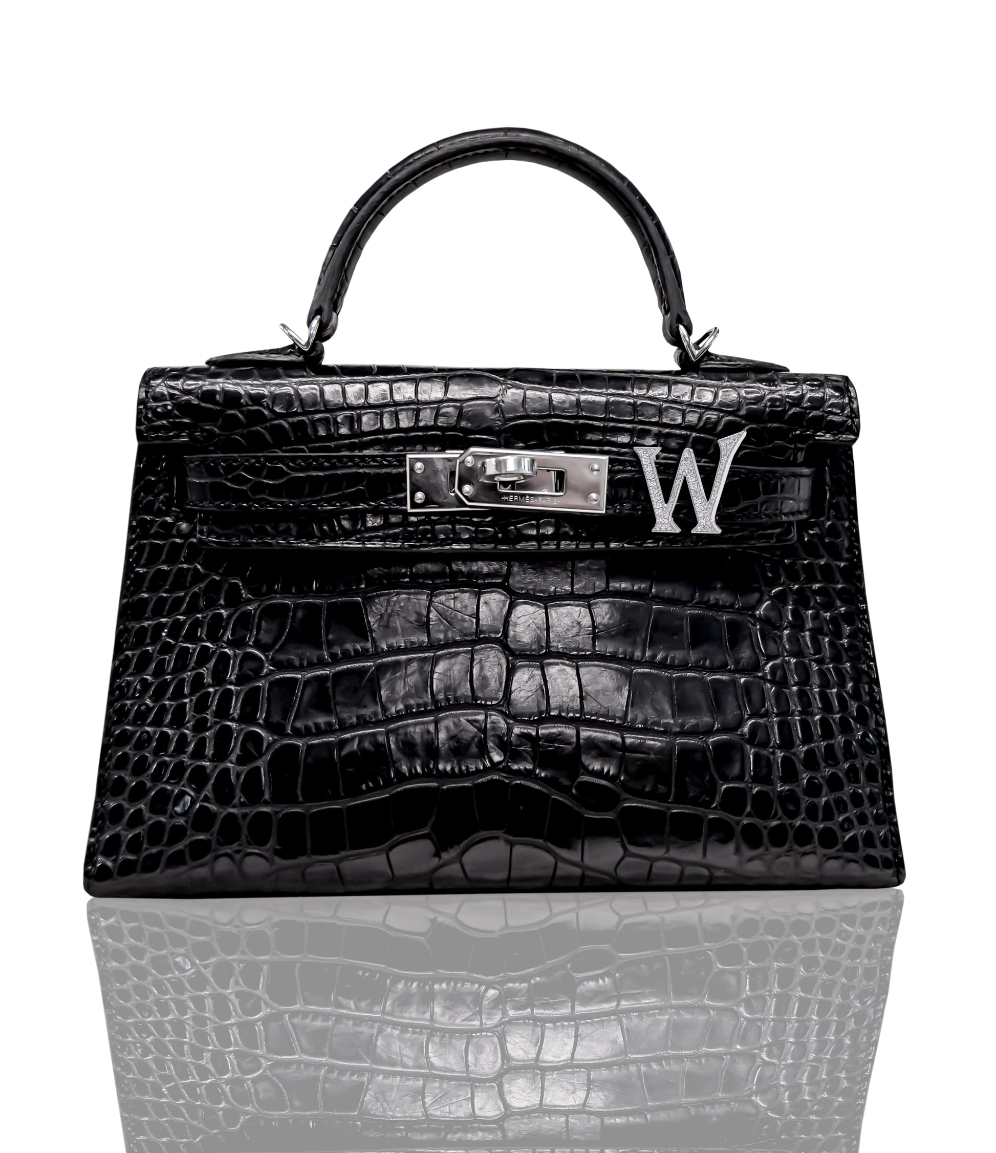 A black handbag with a crocodile pattern featuring a brooch with a 'W' initial, collection-preview.