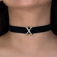 Black choker with a gold 'X' on a person's neck