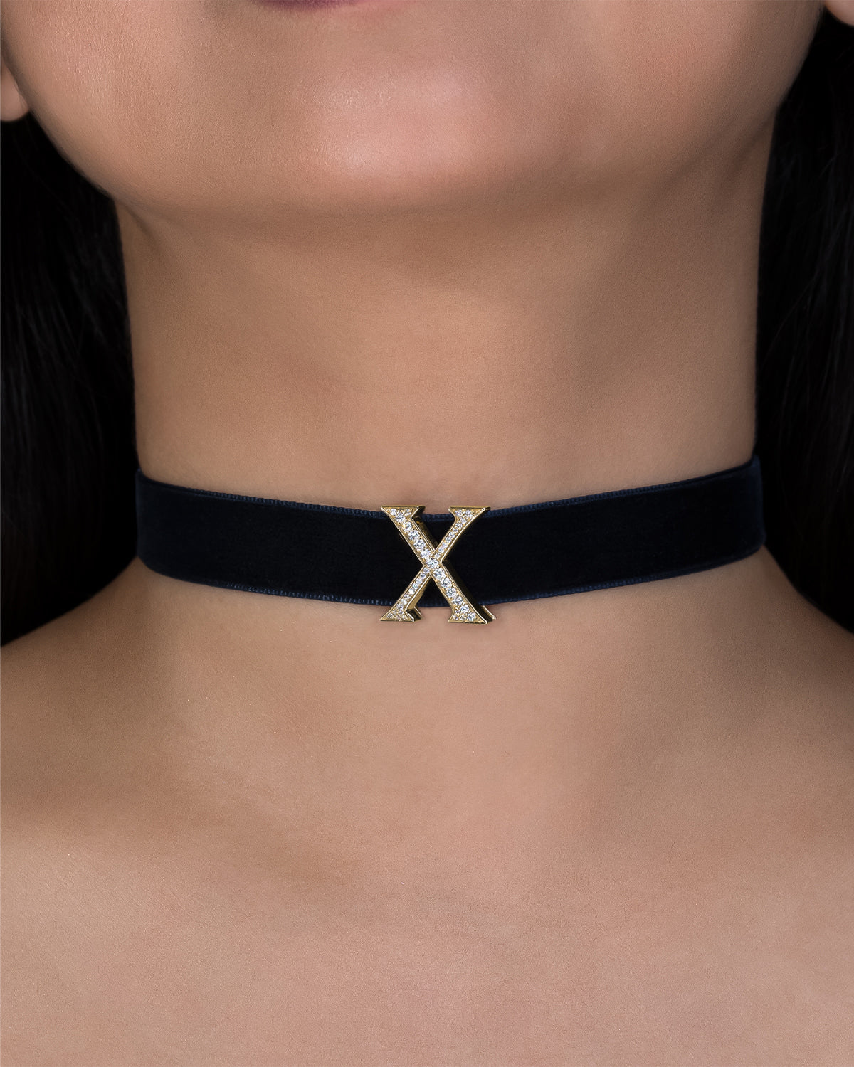 Black choker with a gold 'X' on a person's neck
