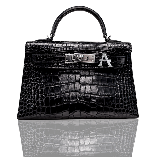 Black crocodile skin handbag with a visible brand logo on a white background, collection-preview.