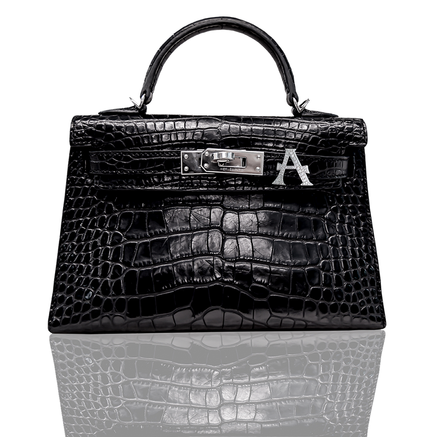 Black crocodile skin handbag with a visible brand logo on a white background, collection-preview.