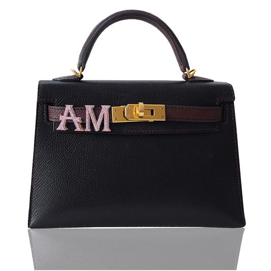 Black handbag with gold hardware and a decorative band on a white , collection-previewbackground